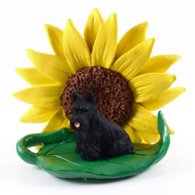 Scottish Terrier Figurine Sitting on a Green Leaf in Front of a Yellow Sunflower