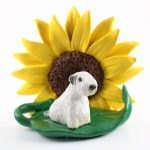 Sealyham Terrier Figurine Sitting on a Green Leaf in Front of a Yellow Sunflower