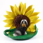 Shih Tzu Black/White Figurine Sitting on a Green Leaf in Front of a Yellow Sunflower