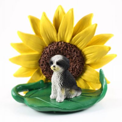 Shih Tzu Black/White Puppy Cut Figurine Sitting on a Green Leaf in Front of a Yellow Sunflower