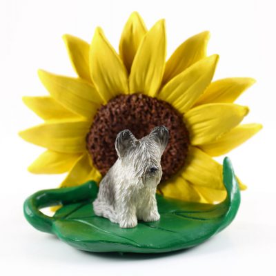 Skye Terrier Figurine Sitting on a Green Leaf in Front of a Yellow Sunflower