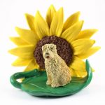 Soft Coated Wheaten Figurine Sitting on a Green Leaf in Front of a Yellow Sunflower