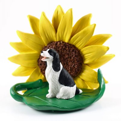 Springer Spaniel Black Figurine Sitting on a Green Leaf in Front of a Yellow Sunflower