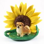 Tibetan Spaniel Figurine Sitting on a Green Leaf in Front of a Yellow Sunflower